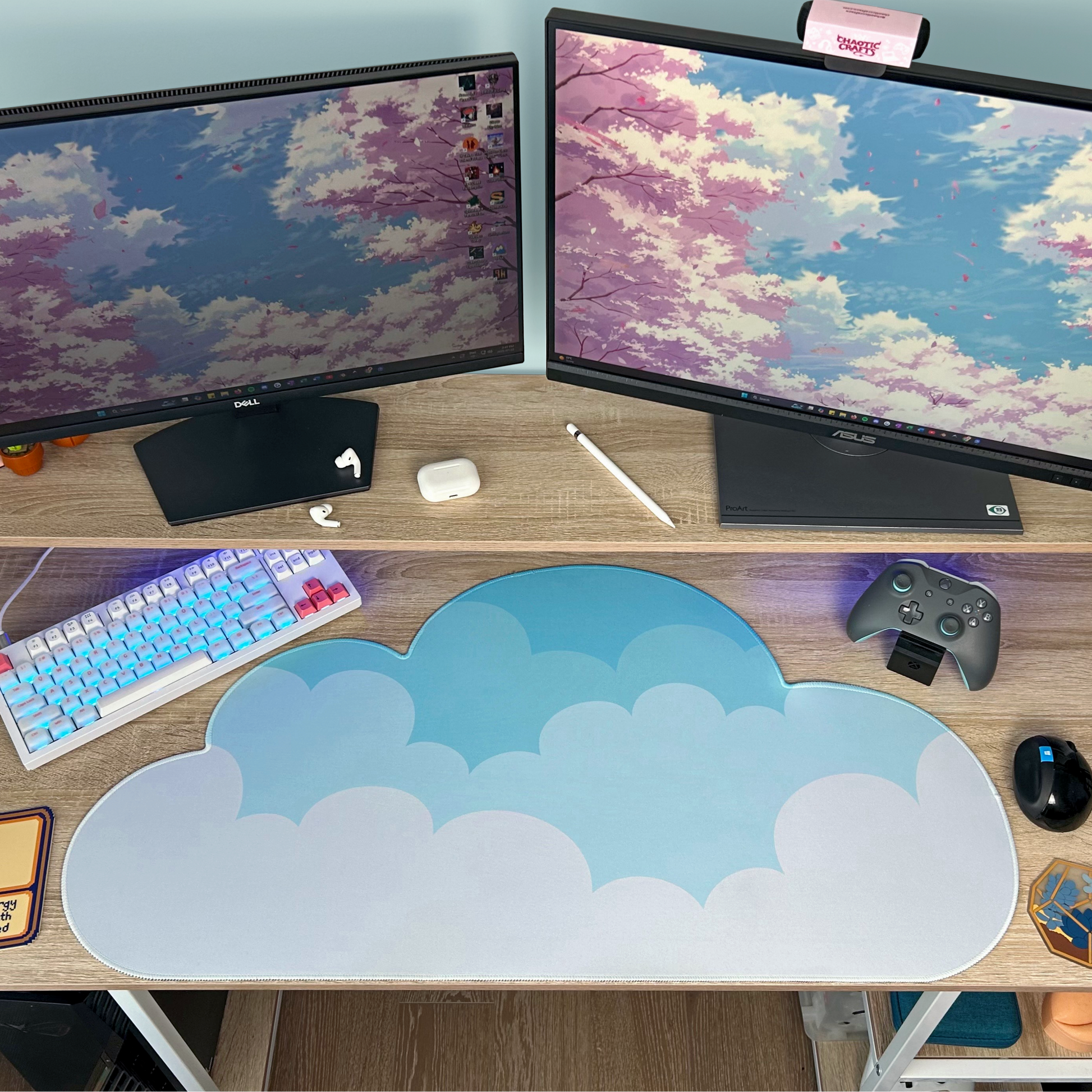 Computer setup with two monitors with a sky blue to white ombre cloud shaped desk mat on a desk.
