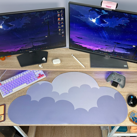 Computer setup with dual monitors, keyboard, mouse, and cloud-shaped mouse pad on a desk.