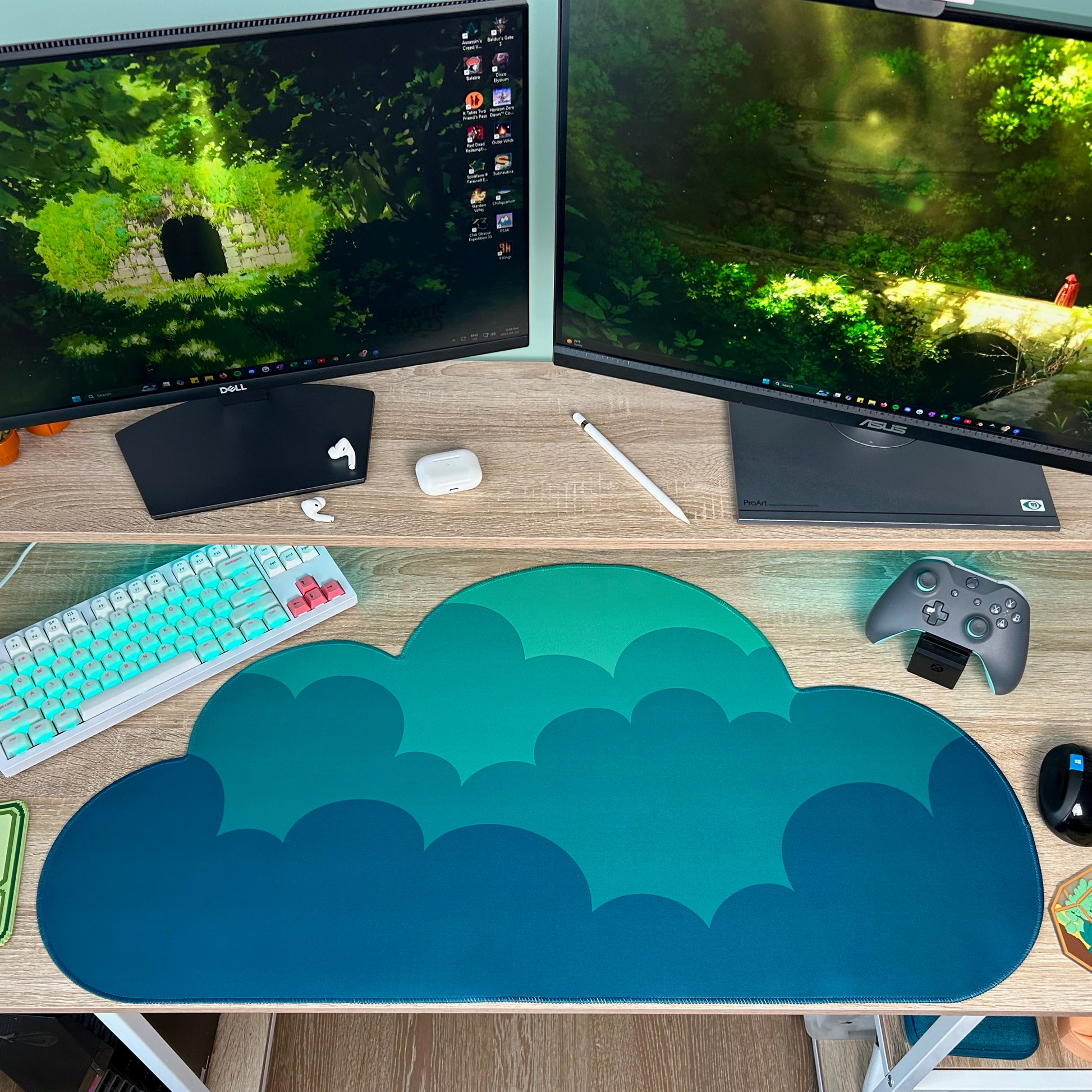 Computer setup with dual monitors, keyboard, mouse, and cloud-shaped dark green ombre mouse pad on a desk.
